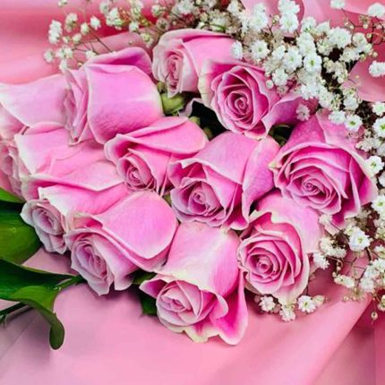 Elegant hand bouquet of 12 premium pink roses with baby's breath and luxury pink wrapping for same-day flower delivery in Qatar.