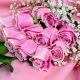 Elegant hand bouquet of 12 premium pink roses with baby's breath and luxury pink wrapping for same-day flower delivery in Qatar.
