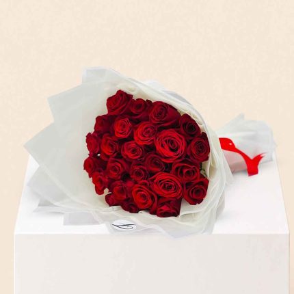 Luxury bouquet of 20 fresh red roses beautifully wrapped in elegant white paper for romantic occasions with same-day flower delivery in Doha, Qatar.